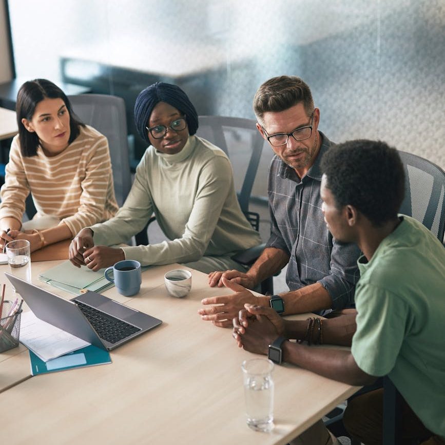 a group of people having a meeting in the office